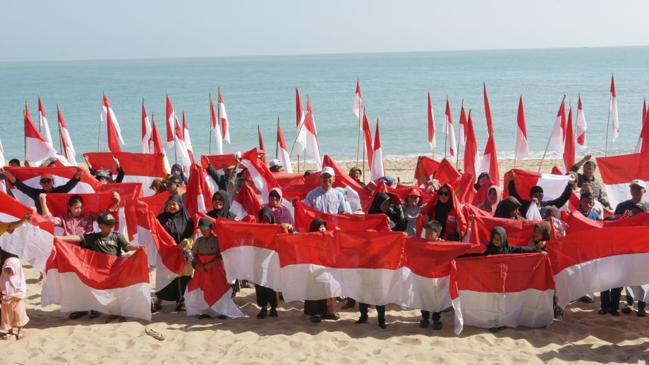 Pembagian Bendera Merah Putih kepada Masyarakat di Pantai Tanjung Api Desa Sebubus, Paloh